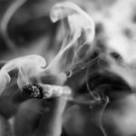 Closed-up of woman holding a cigarette with a thick smoke, which is the header image of "cannabis smoking and growing to be legal" blog.