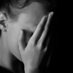 Closed-up of a girl covering her face with her hand and that represents as the header of "sexual bullying in school" blog.